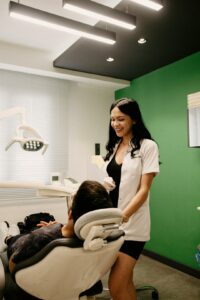 A dental hygienist talking with a family about healthy teeth in a bright, welcoming clinic setting.